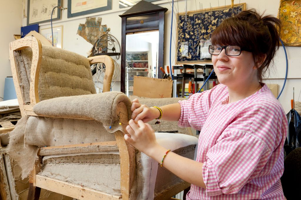 Møbeltapeteserer stopper en lenestol. Foto.