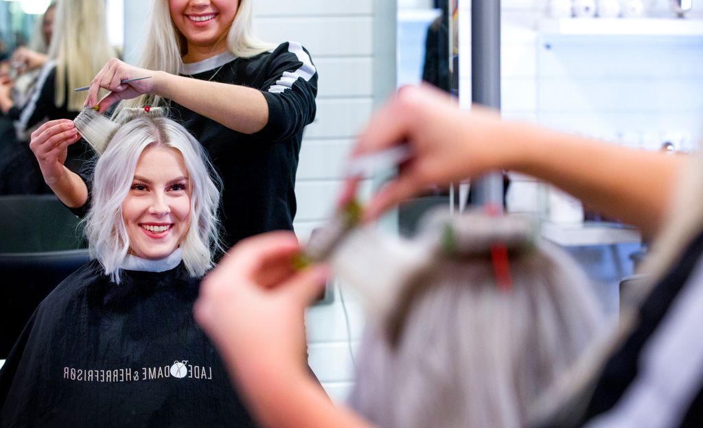Kvinne får krøllet håret hos en frisør. Foto.