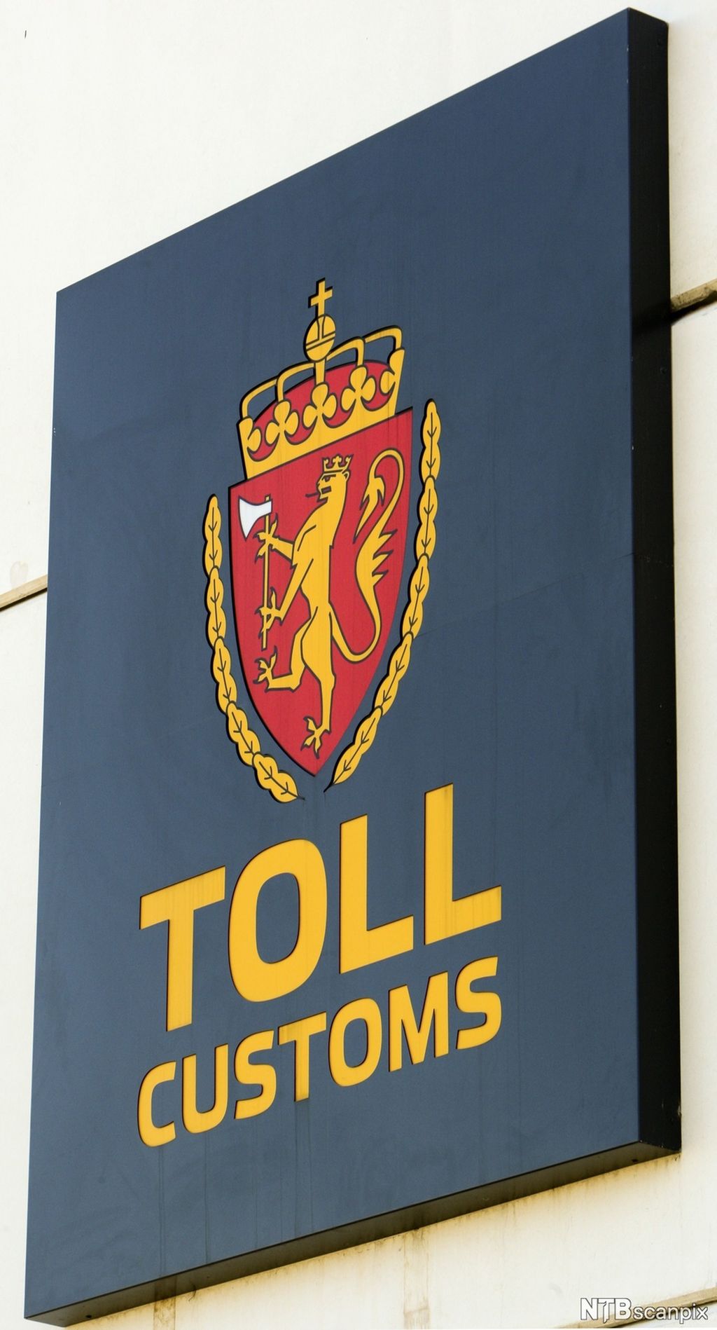Toll-skilt med riksvåpen. Foto.
