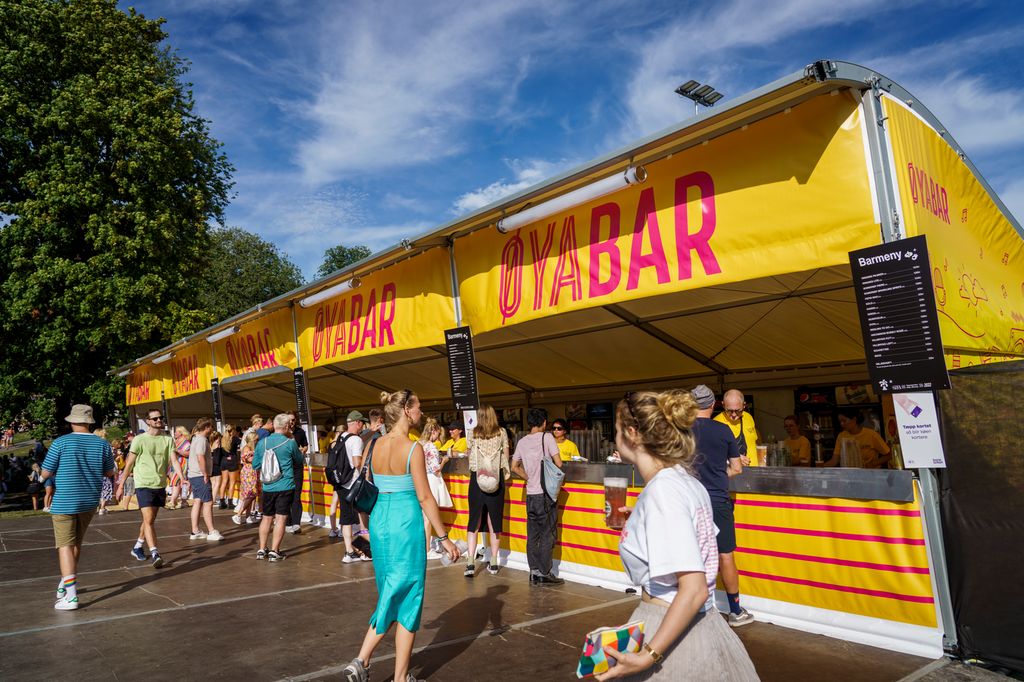 Sommerkledde personer i kø foran et telt med servering. På teltet står det Øya bar. Foto.
