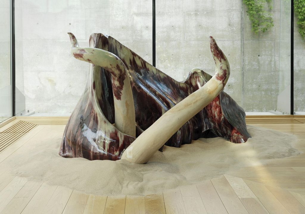 Keramikkskulptur med organiske former som minner om horn og kroppsdeler fra en okse. Foto.