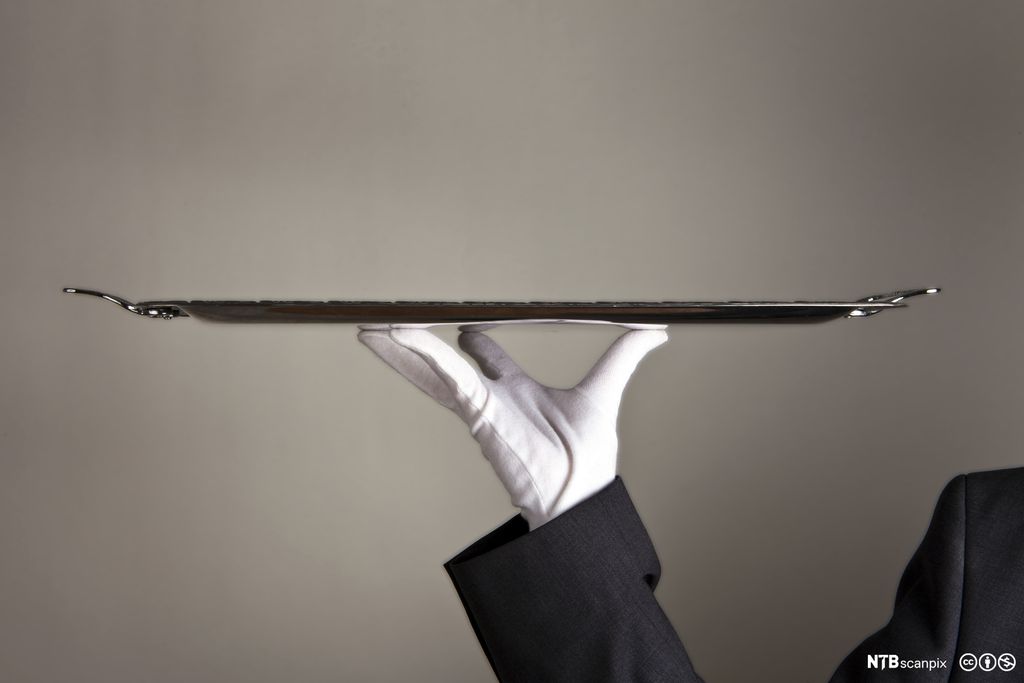 Person med hvit hanske som holder et serveringsbrett