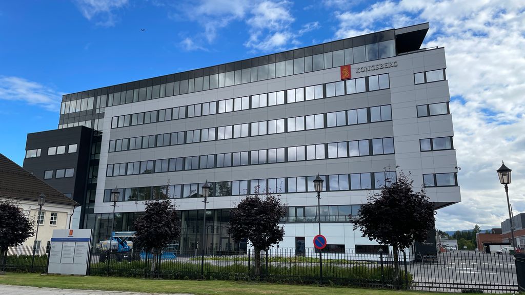 Stor grå bygning på sju etasjer. Foto. 
