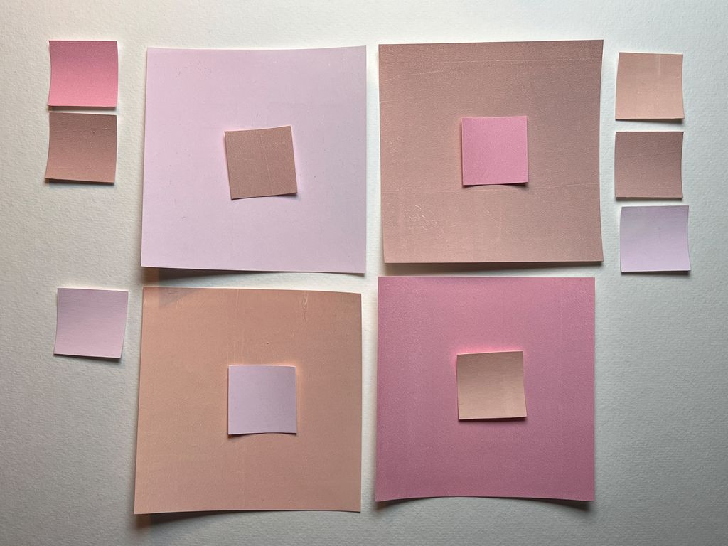 Kvadratiske rosa papirbiter. Foto.