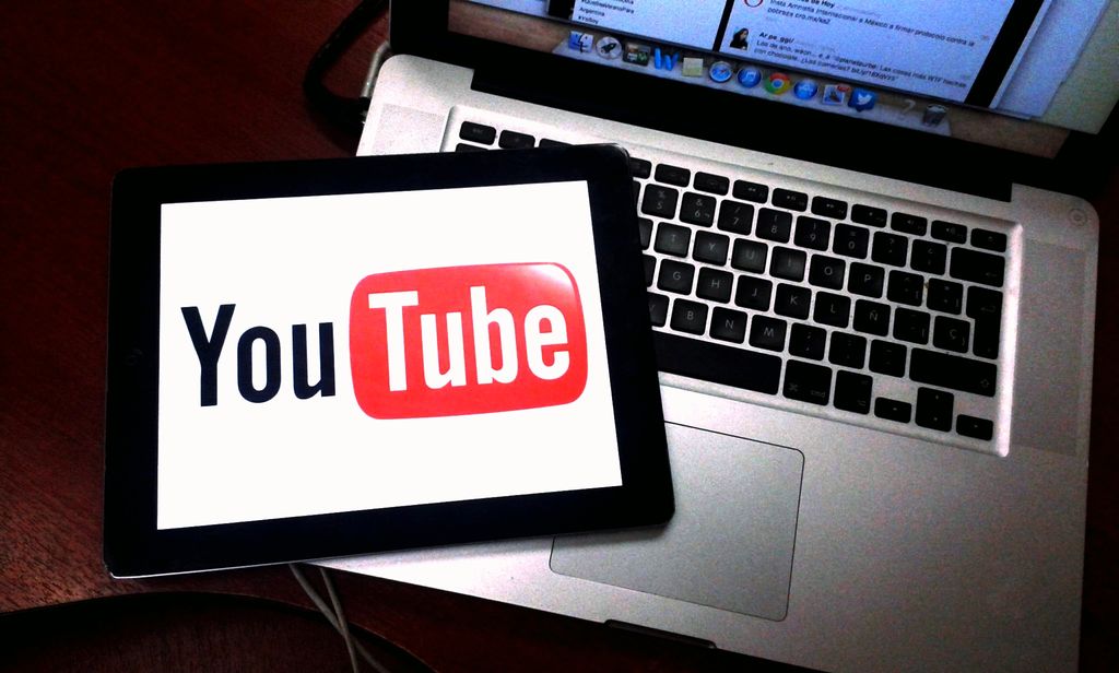 Et nettbrett oppå en pc hvor YouTube-logoen dekker nettbrettet. Foto. 