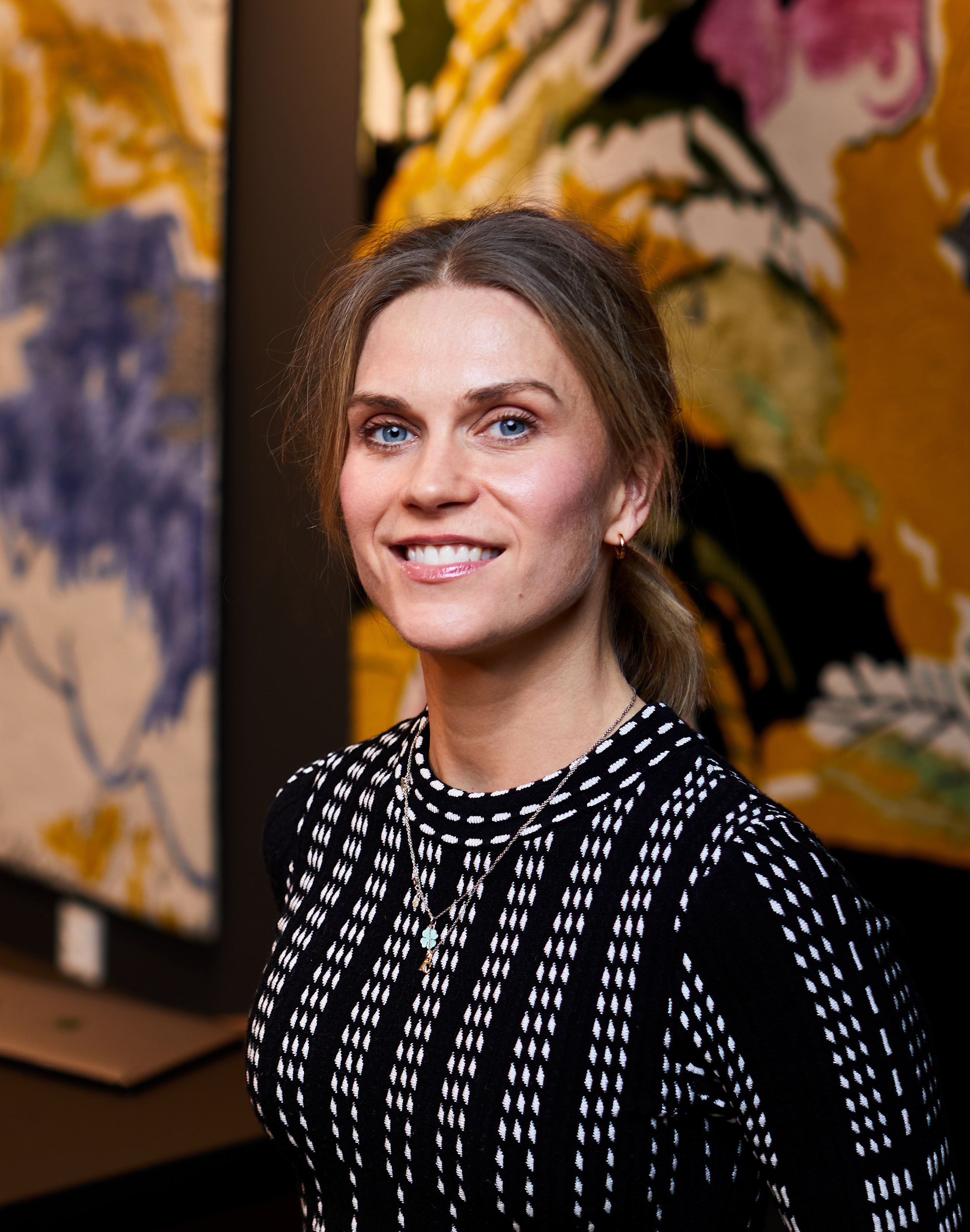 Ung dame foran dekorative tapeter. Foto.