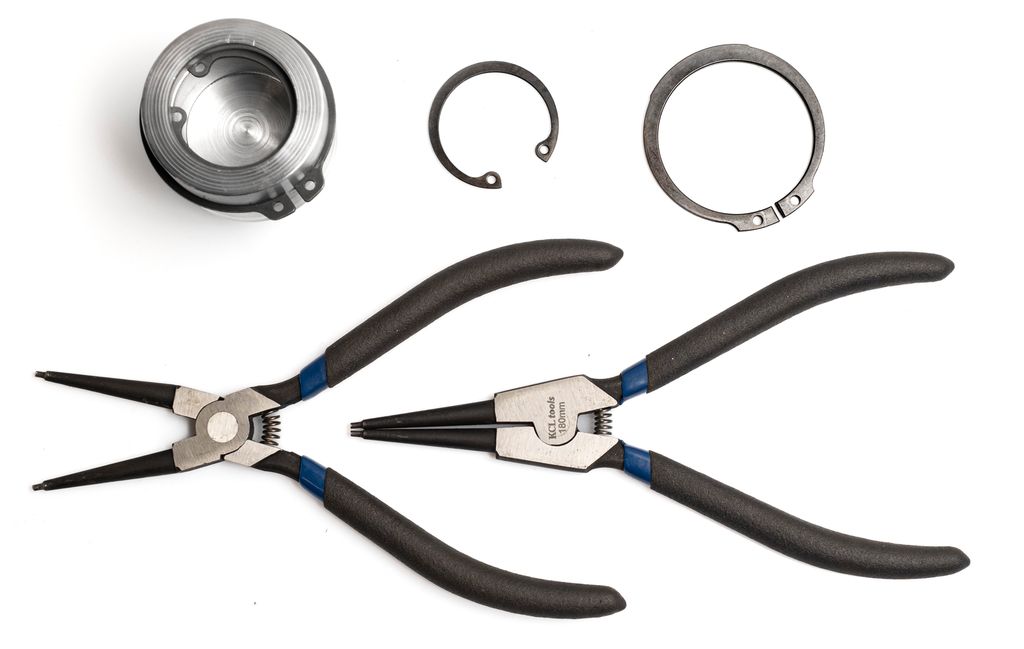 To tenger, to låseringer og en sylinder med låseringer montert. Foto.