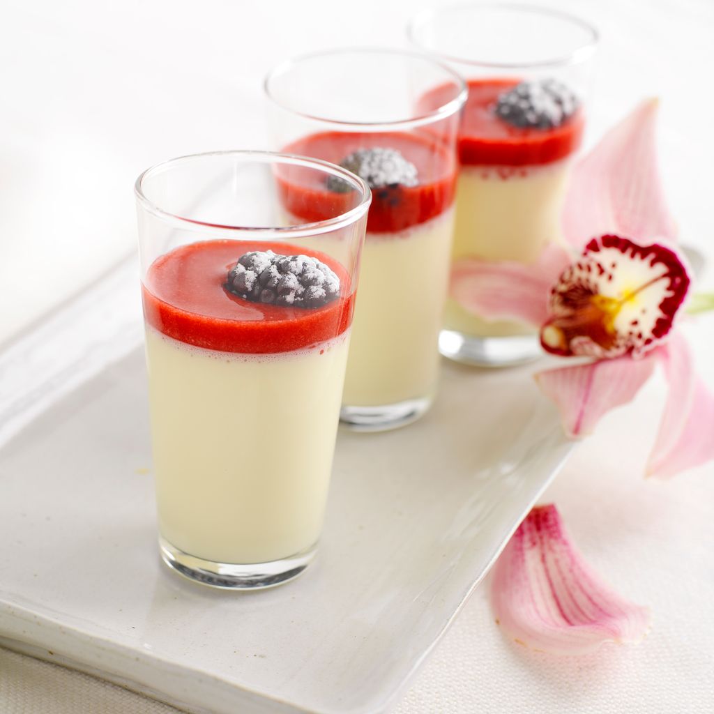 Pannacotta i glass med bringebærcoulis og bjørnebær. Foto.