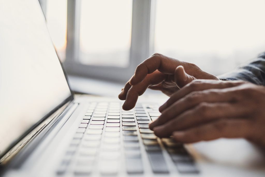 Person skriver på laptop. Nærbilde av hender og tastatur. Foto.
