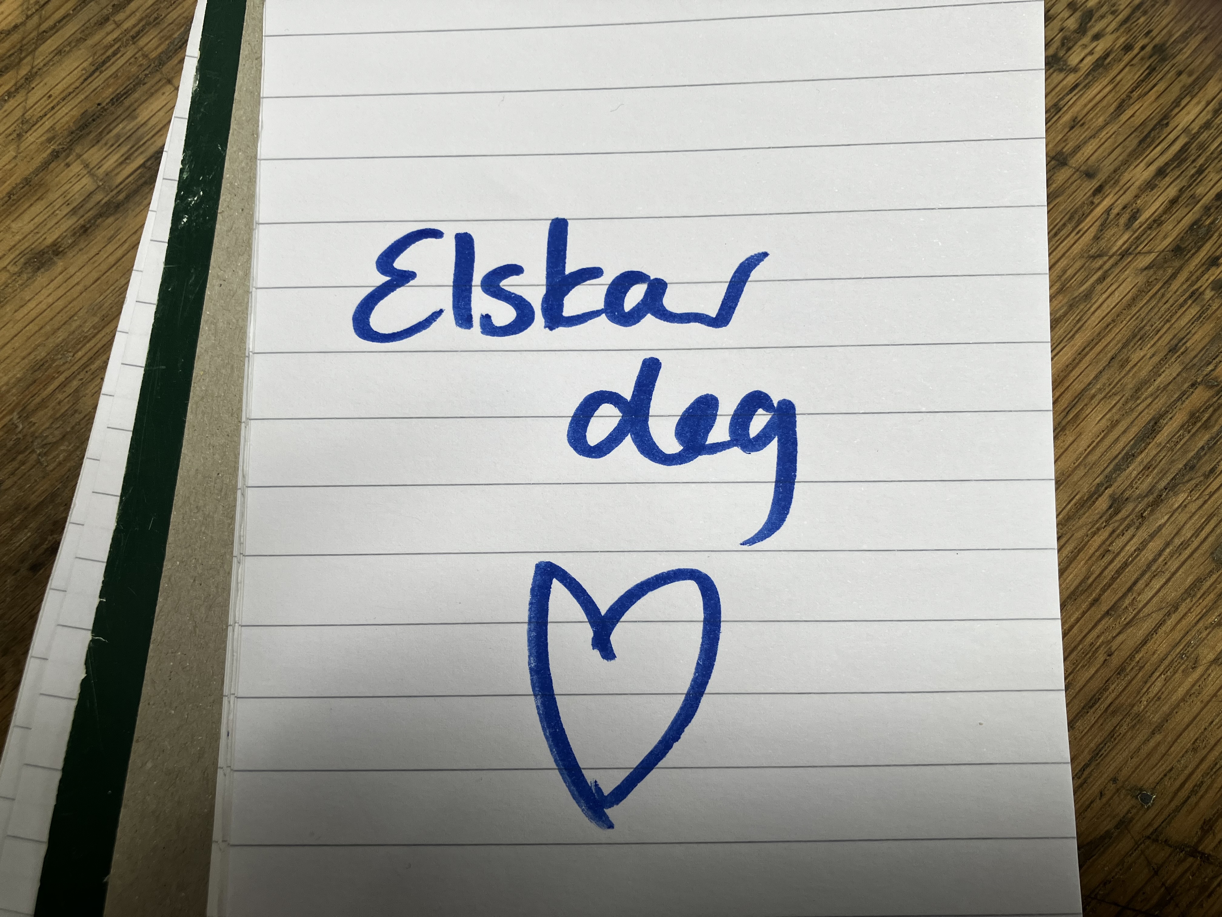 "Elskar deg!" skrive på ein papirbit. Under dette er eit hjarte teikna med same tusj. Foto.