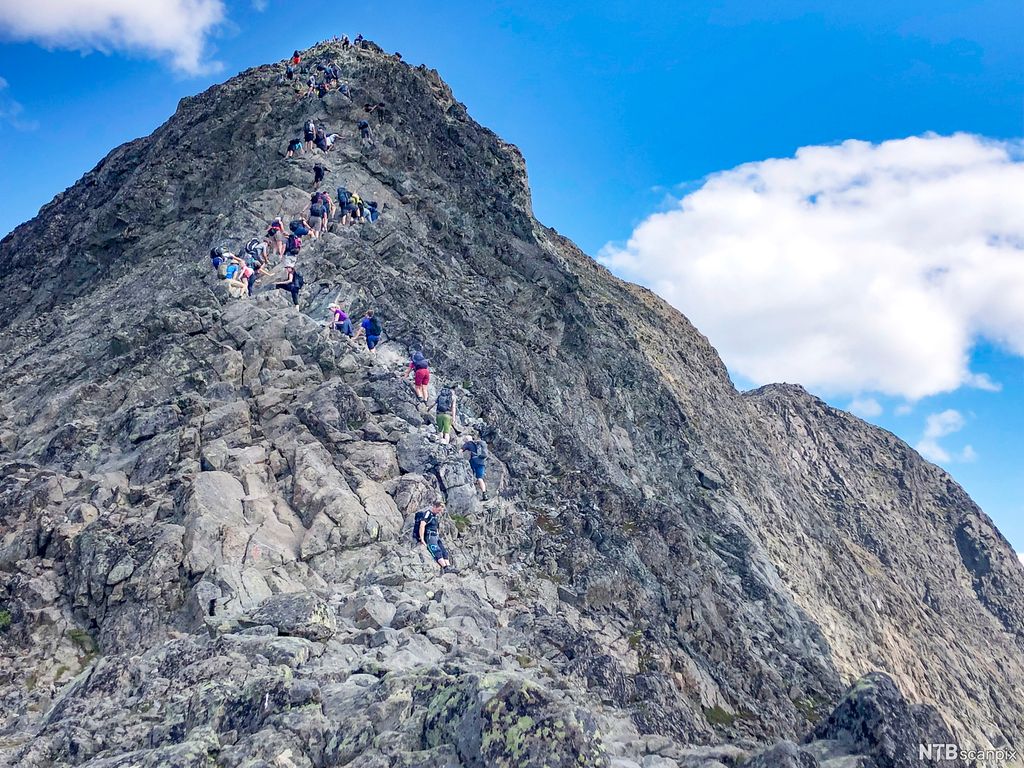 Ei kø av menneske på tur opp Besseggen. Foto.