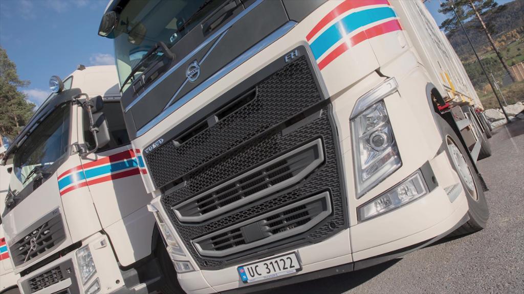 Nærbilete av fronten på to kvite lastebilar. Foto.