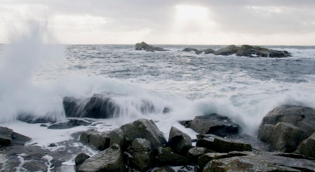 Bølger som slår mot store steiner og skjær. Foto.
