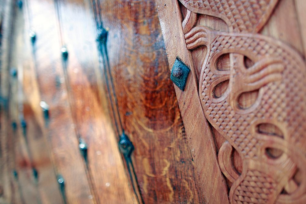 Detalj fra et vikingskip dekorert med utskjæringer av et fabeldyr. Foto.