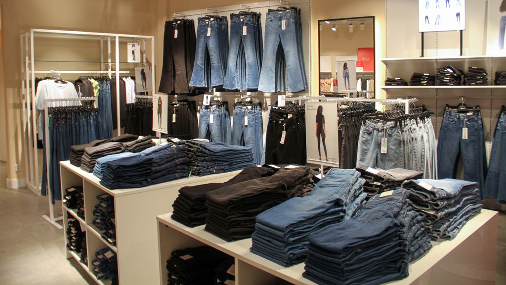 Utsnitt fra klesbutikken Gina Tricot på Lagunen kjøpesenter i Bergen, oktober 2020. Bukser henger langs veggene, og pent sammenbrettede bukser ligger på et bord midt i rommet. Foto.