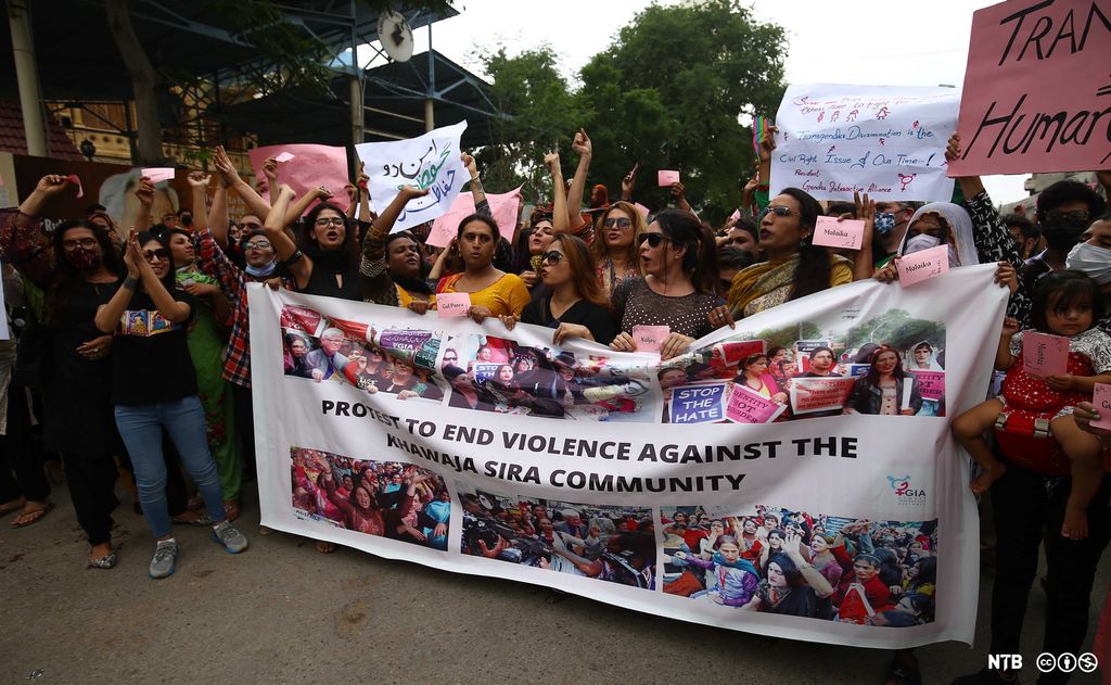 Ei gruppe personar protesterer med banner. Foto