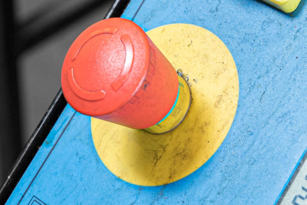 Nødstoppbryter på betjeningspanel for båndsag. Foto.