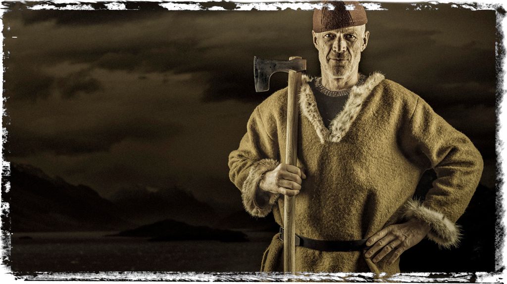 En viking holder opp skjeggøksen sin. Foto.