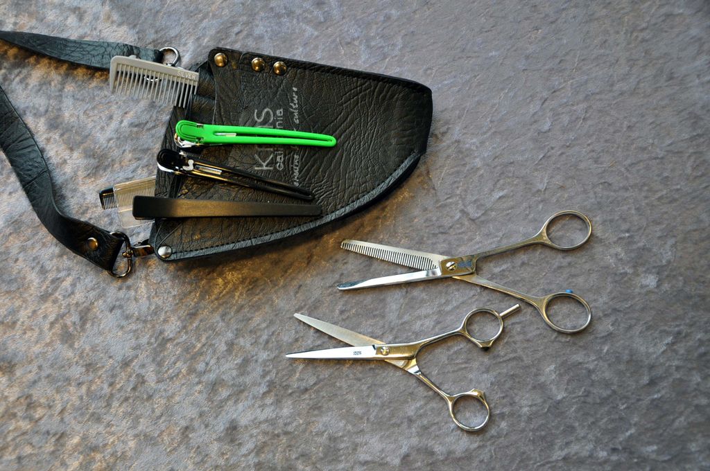 Diverse frisørutstyr, som sakser og hårspenner. Foto. 