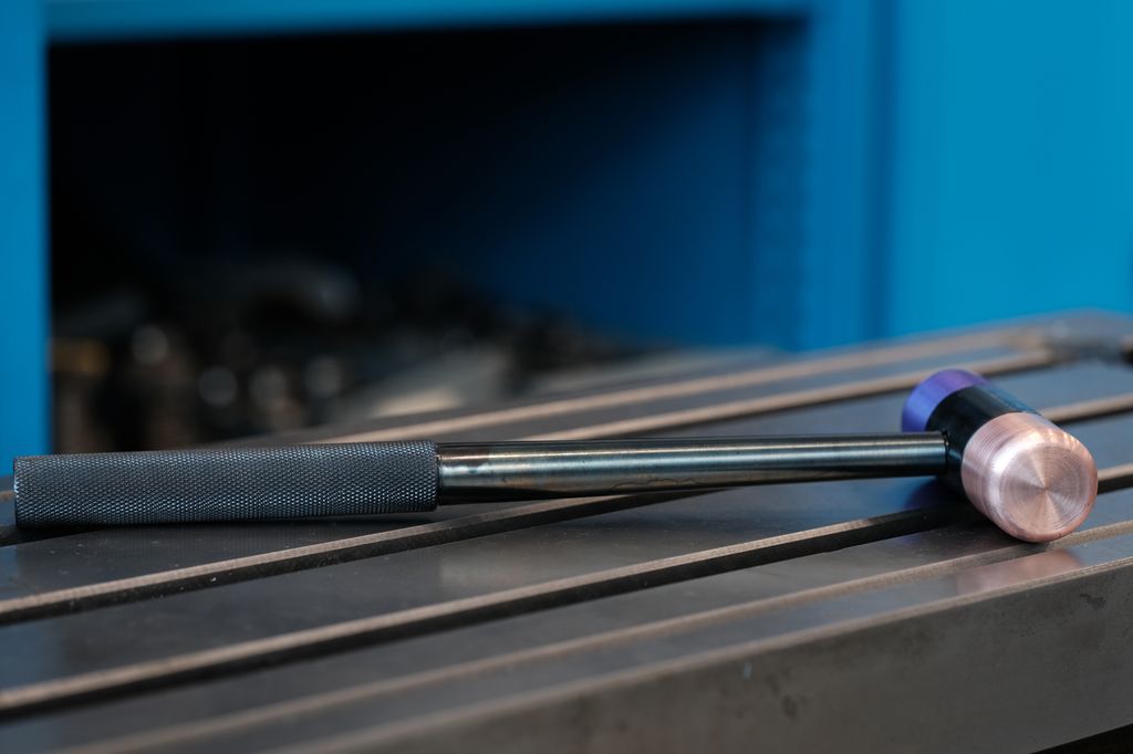 Hammer liggende på et metallbord. Foto.