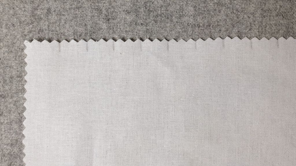 Fotografi som viser ein stoffbit som er markert med små blyantstrekar med jamn avstand på den øvste langsida.