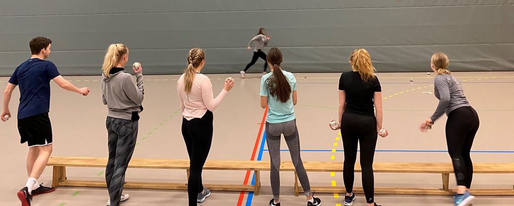 Elever som forsøker å treffe et mål i bevegelse, med papirballer. Foto.