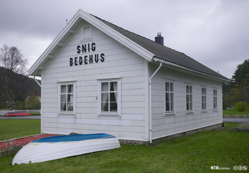 Et lite, hvitt hus med skiltet Snig bedehus. Foto.