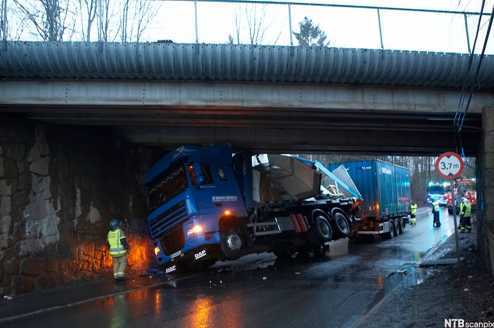 Et vogntog har kjørt seg fast under en bro. Foto.