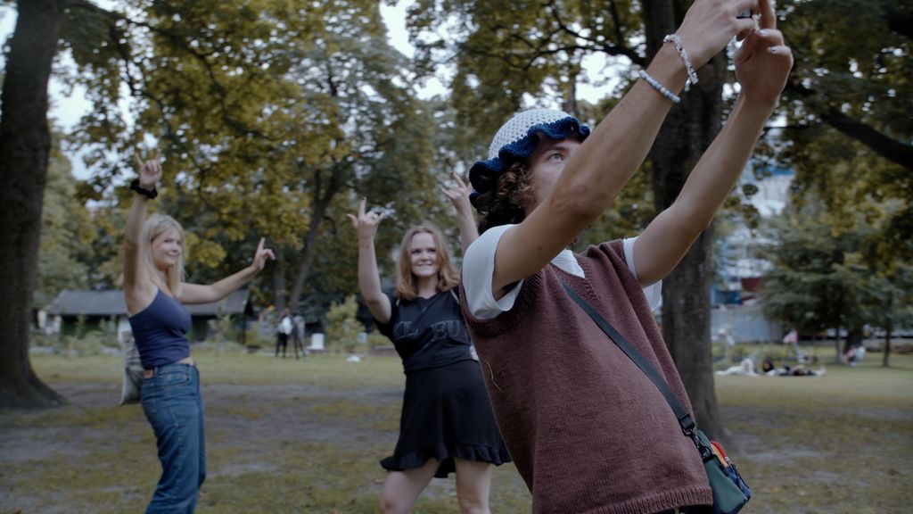Tre ungdommer leker seg med å ta selfies i en park. Foto.