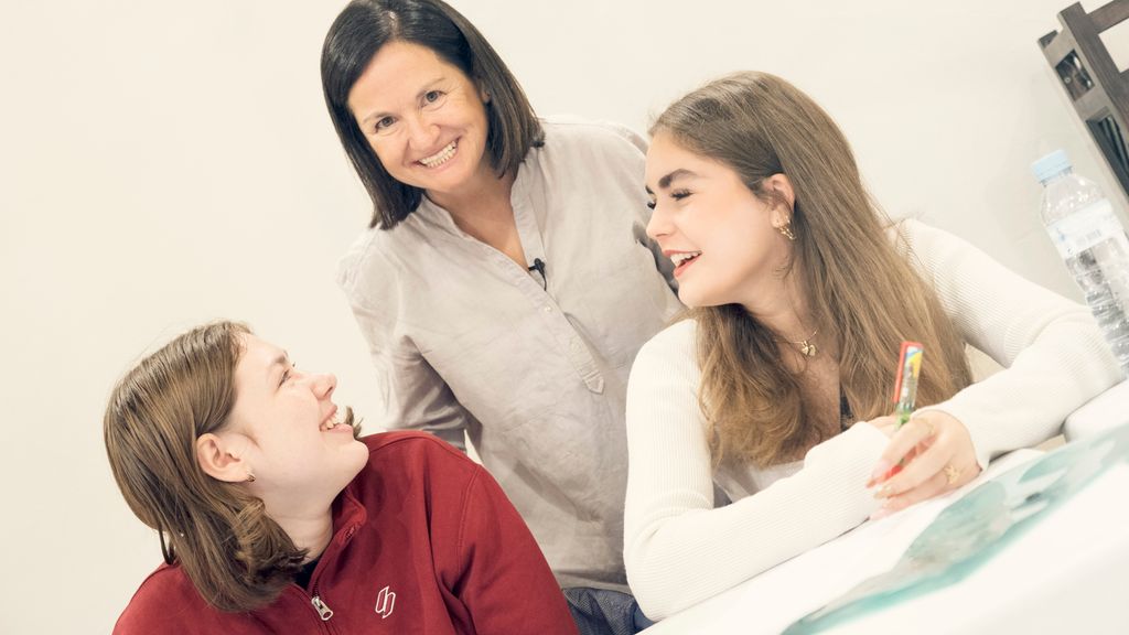 To elever smiler til en lærer som står bak dem. Foto.