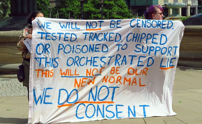 Anti-vaxxers holding a banner protesting against COVID-19 vaccination. Photo.