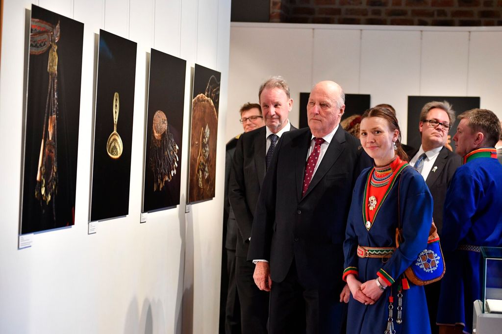Kong Harald ser på samisk kunst. Noen av de tilstedeværende har samiske klær. Foto.