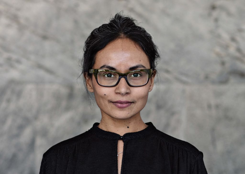 Portrett av selvsikker forretningskvinne som står opp mot en vegg. Foto.