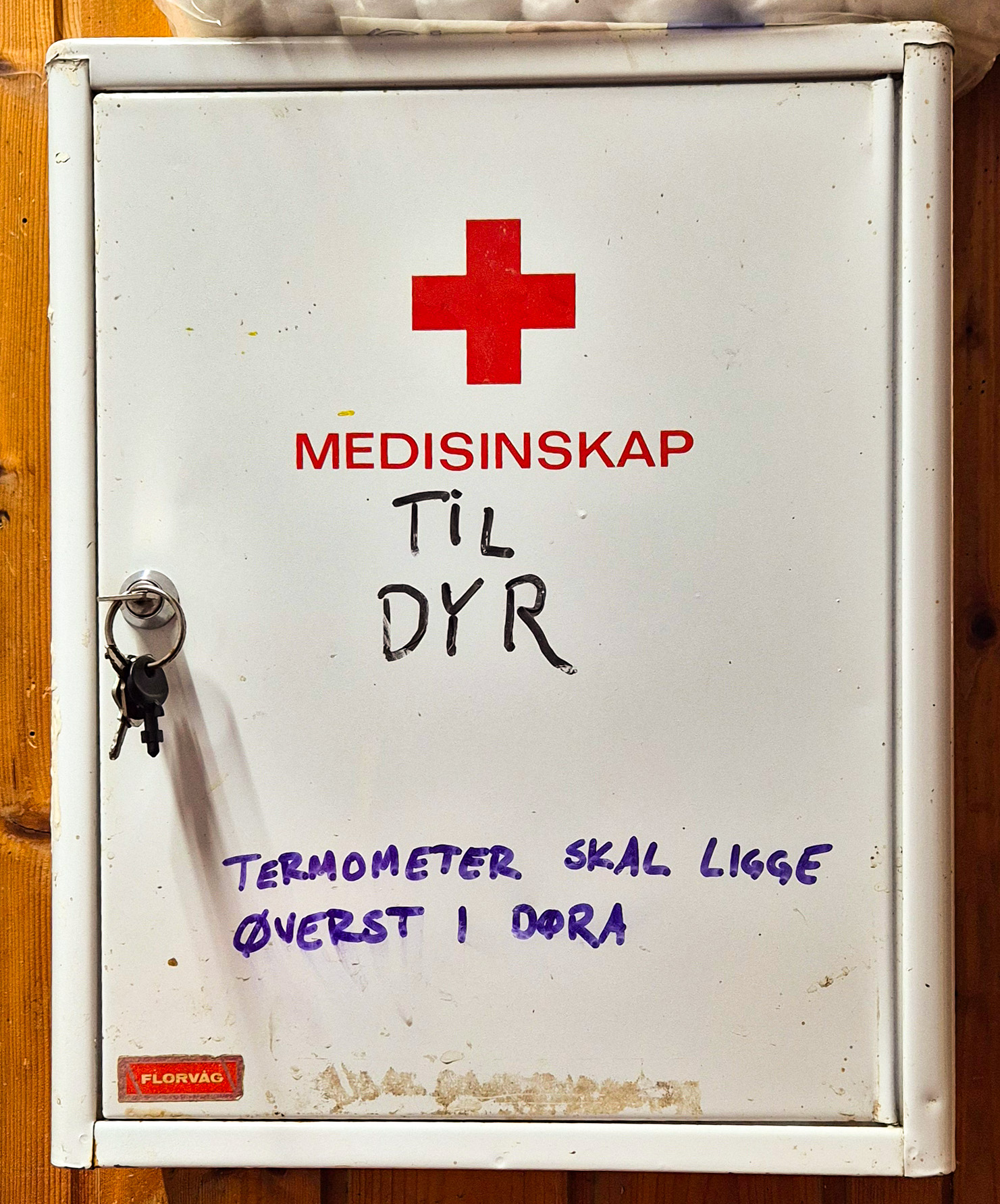 Et vegghengt medisinskap med påskriften "til dyr". Nøklene henger i døra. Foto.