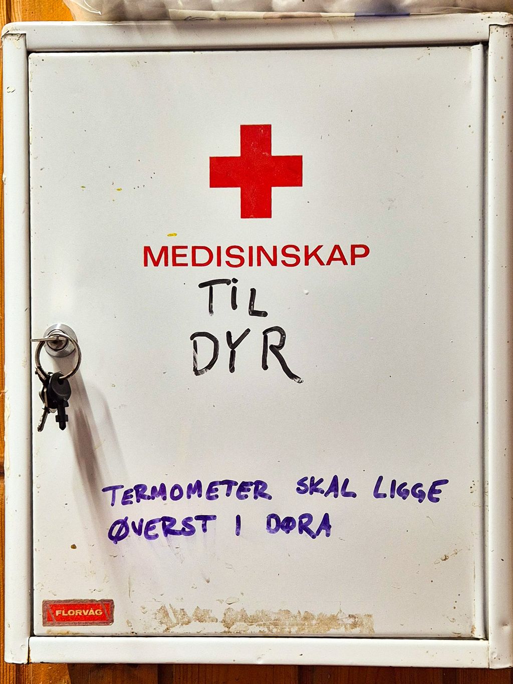 Et vegghengt medisinskap med påskriften "til dyr". Nøklene henger i døra. Foto.