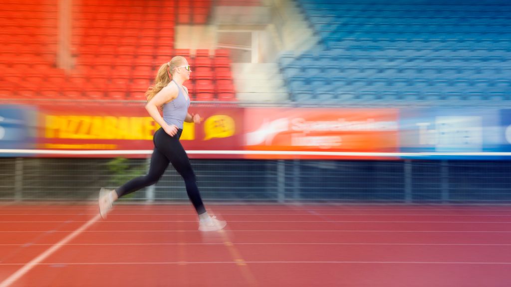Jente jogger på et stadion. Foto.