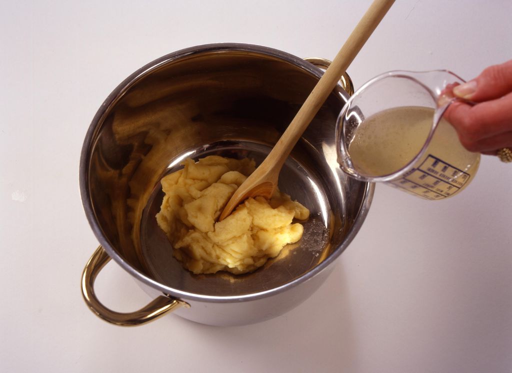 En kjele med lys jevning og en mugge med væske til å spe den med. Foto.