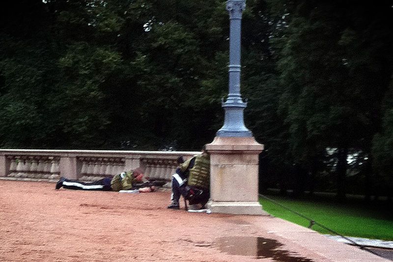 To gardister med paradeuniform og skuddsikre vester. En ligger og sikter med gevær. En annen sitter i skjul. Foto.