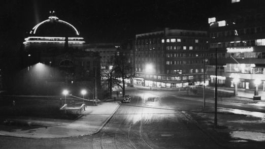 Fotografi som viser historisk bybilete med lysskilt.
