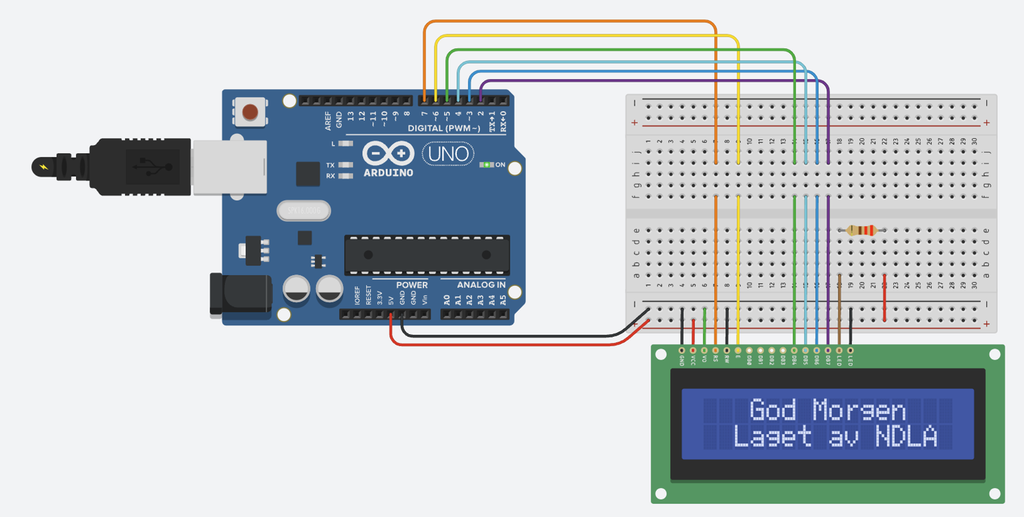 Skjermen viser teksten God Morgen og Laget av NDLA. Komponentene er kopla sammen med ledninger via et koplingsbrett. Illustrasjon.
