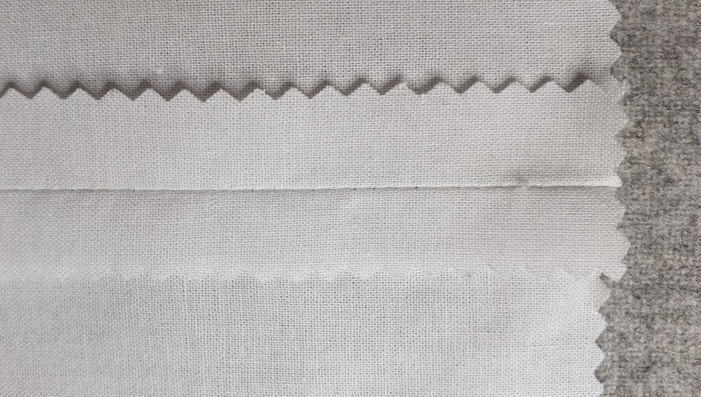 Fotografi av prøvelapp der sømmonnet er presset til hver sin side på vranga.