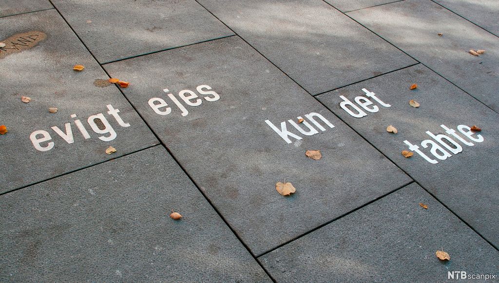 Sitat frå Henrik Ibsen nedfelt på fortau. Tekst: evigt ejes kun det tabte. Karl Johans gate, Oslo. Foto. 