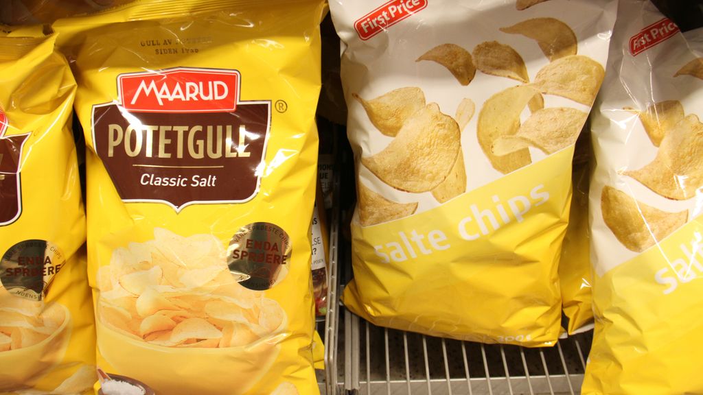 Posar med salt potetgull i to ulike prisklassar og av to ulike merke, Maarud og First Price, side om side i ei butikkhylle. Foto.