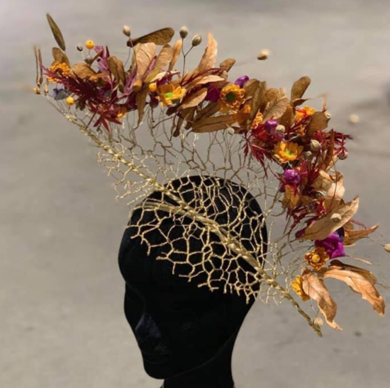 Hodeplagg laget av hønsenetting og blomster. Foto.