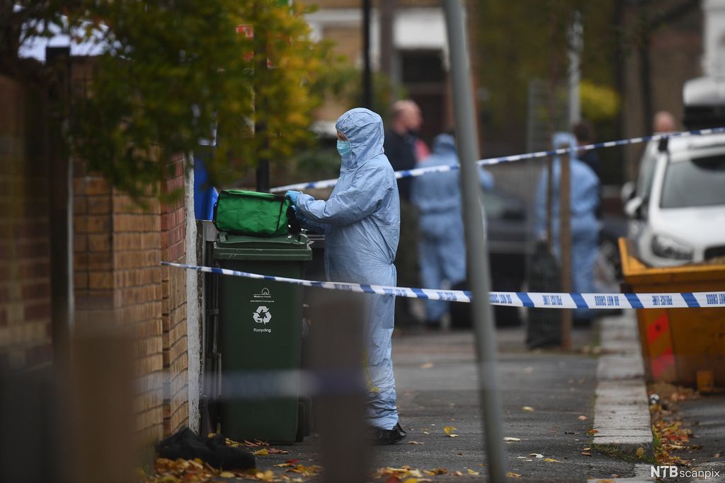 Politietterforsker i beskyttelsesdrakt på avsperret åsted i gate. Foto.
