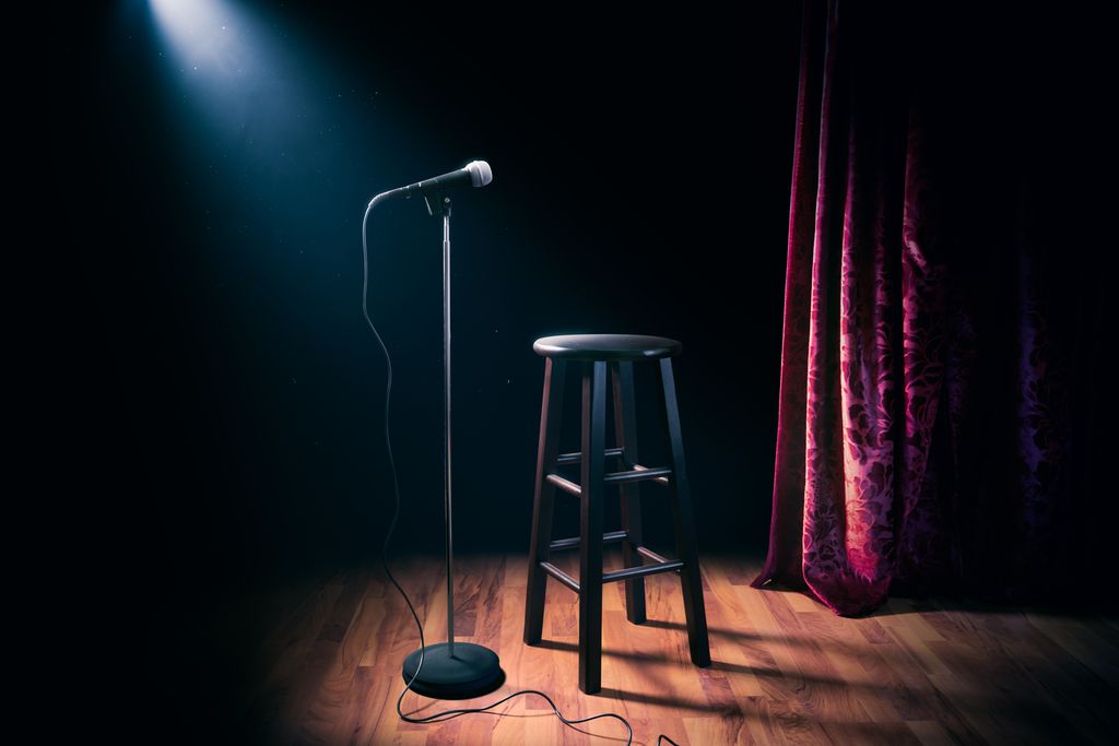A stool and a microphone on a stage. Photo.