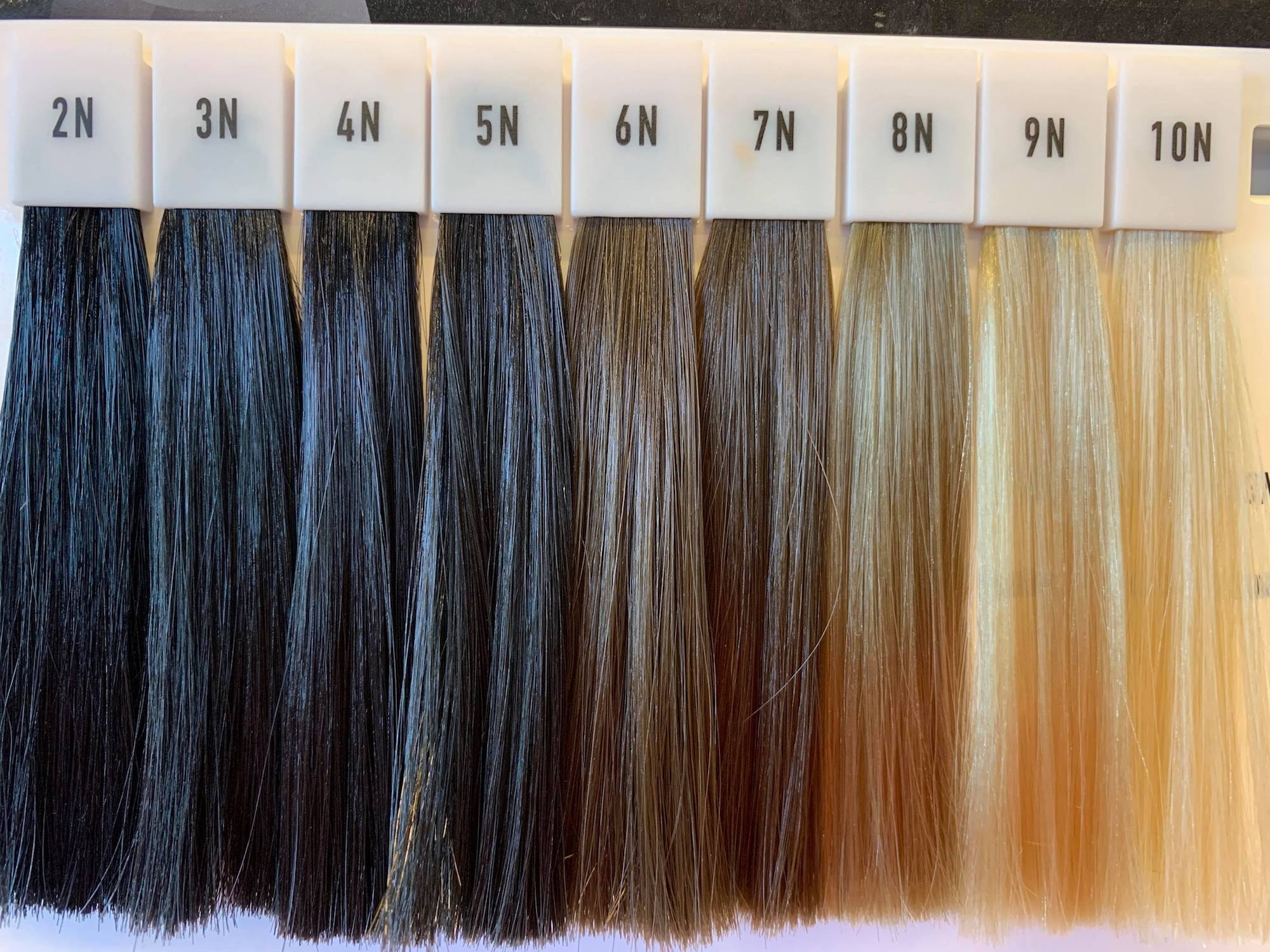 Prøver av ulike hårfarger i en skala fra lys til mørk. Foto.