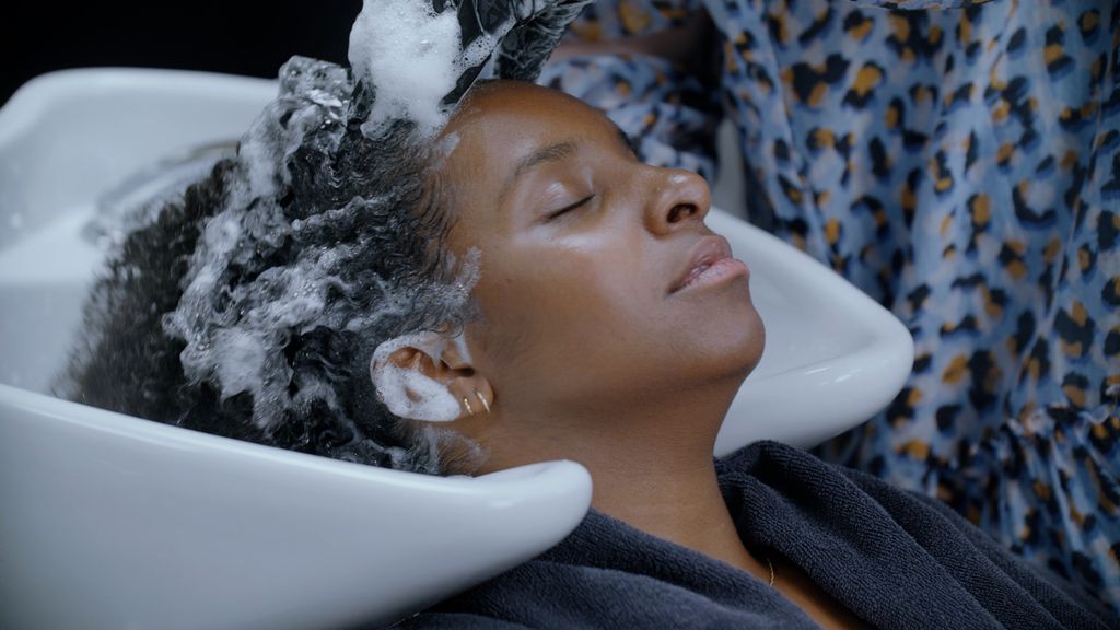 Kvinne får vasket håret hos frisøren. Foto.