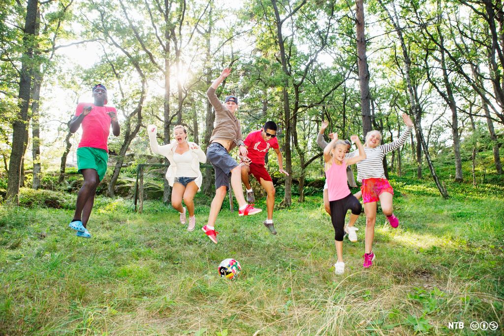 Ein gjeng med ungdommar er ute i naturen. Dei hoppar og ser glade ut. Foto.