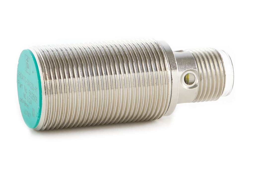 Sylindrisk metalldel med gjenger og med grønn farge på ene enden. Foto.